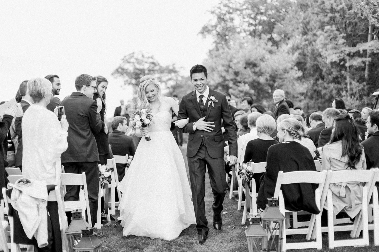 A bride and groom walking down the aisle at their wedding ceremony at the Birchwood Farms Country Club in Harbor Springs, Michigan