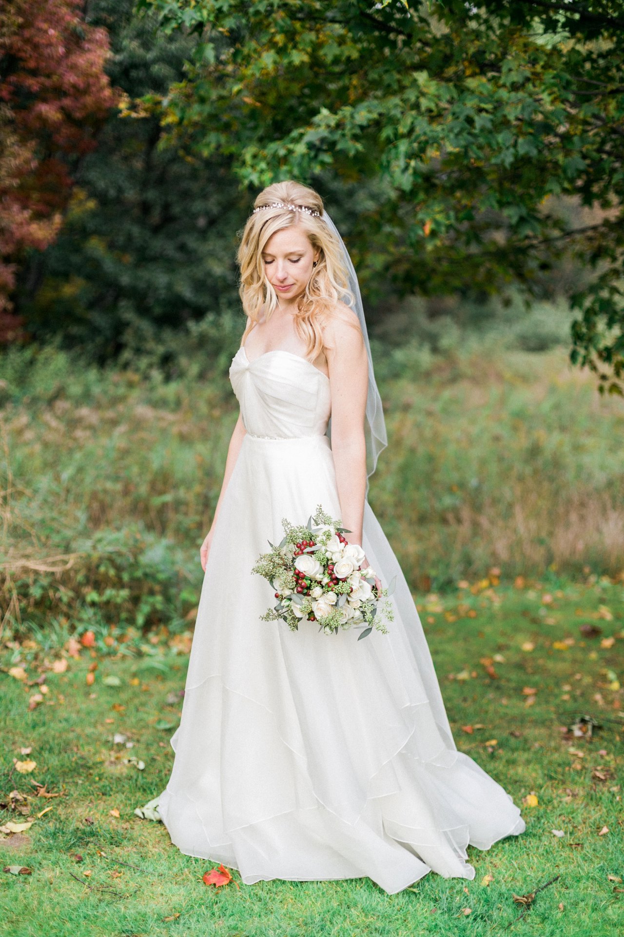 A bride in her Astrid & Mercedes Bridal gown and Monarch Garden & Floral cream & red bouquet in Michigan 