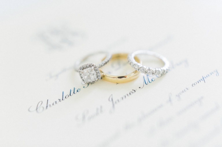 Stunning wedding rings on top of an invitation
