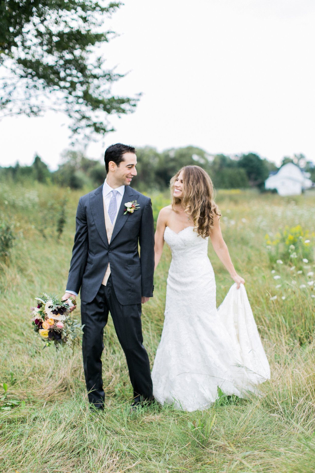 This is a photo of a bride and groom smiling and walking together.