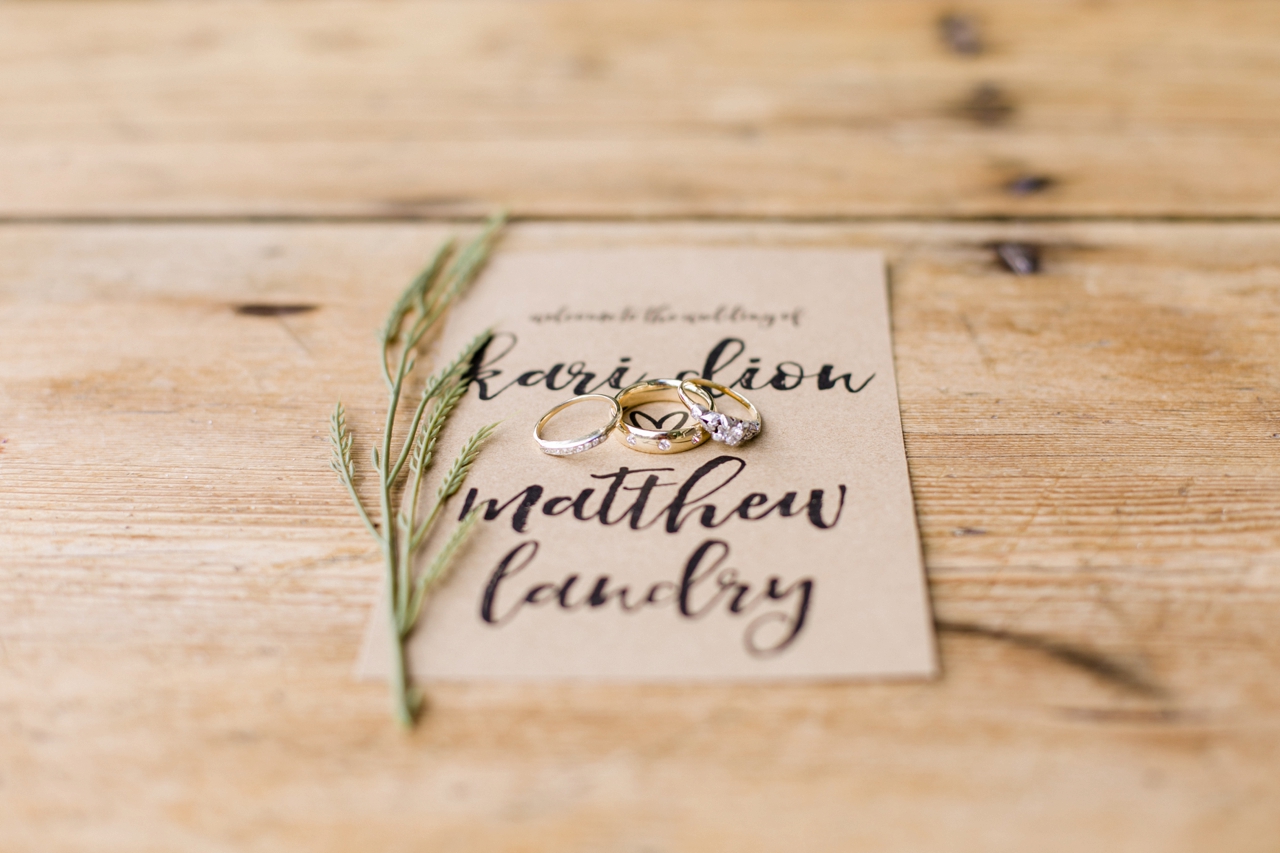 This is a photo of wedding rings and a wedding invitation in Charlevoix, Michigan