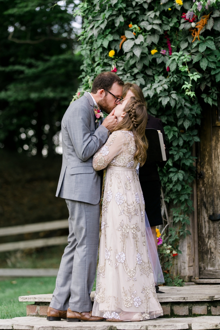 This is a photo of a bride and groom sharing their first kiss as a married couple.