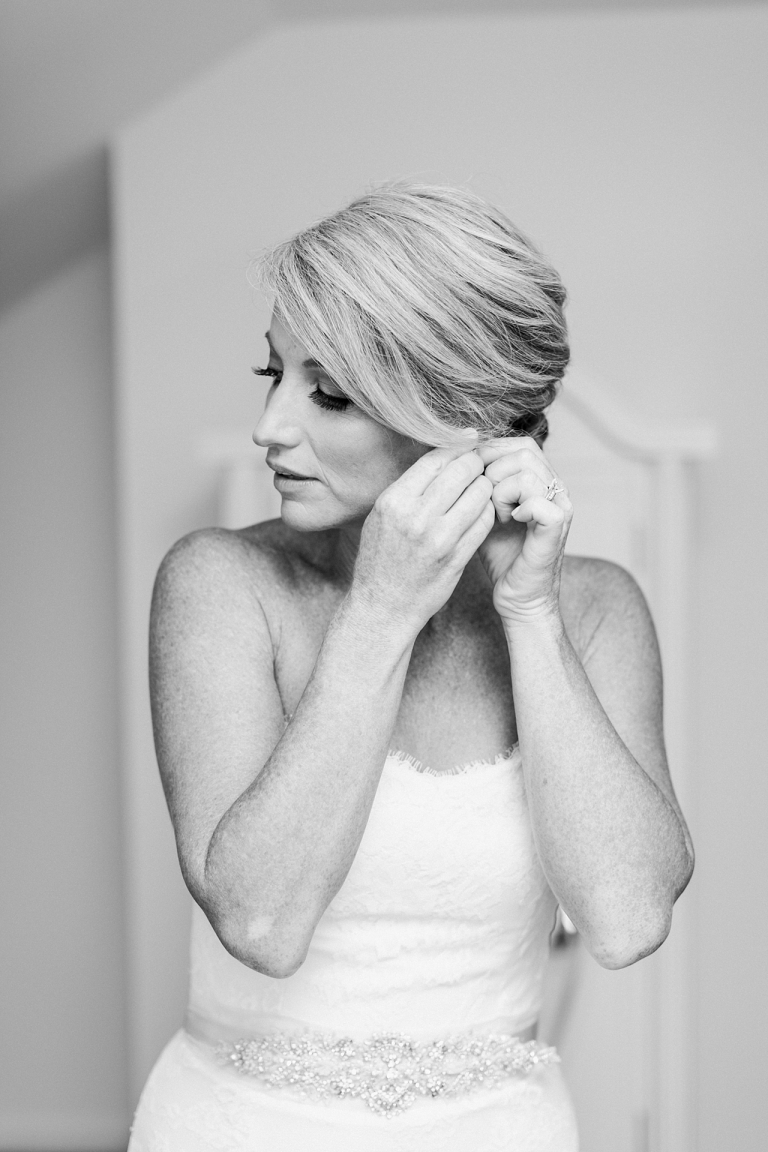 A bride putting on her earrings in Harbor Springs, Michigan