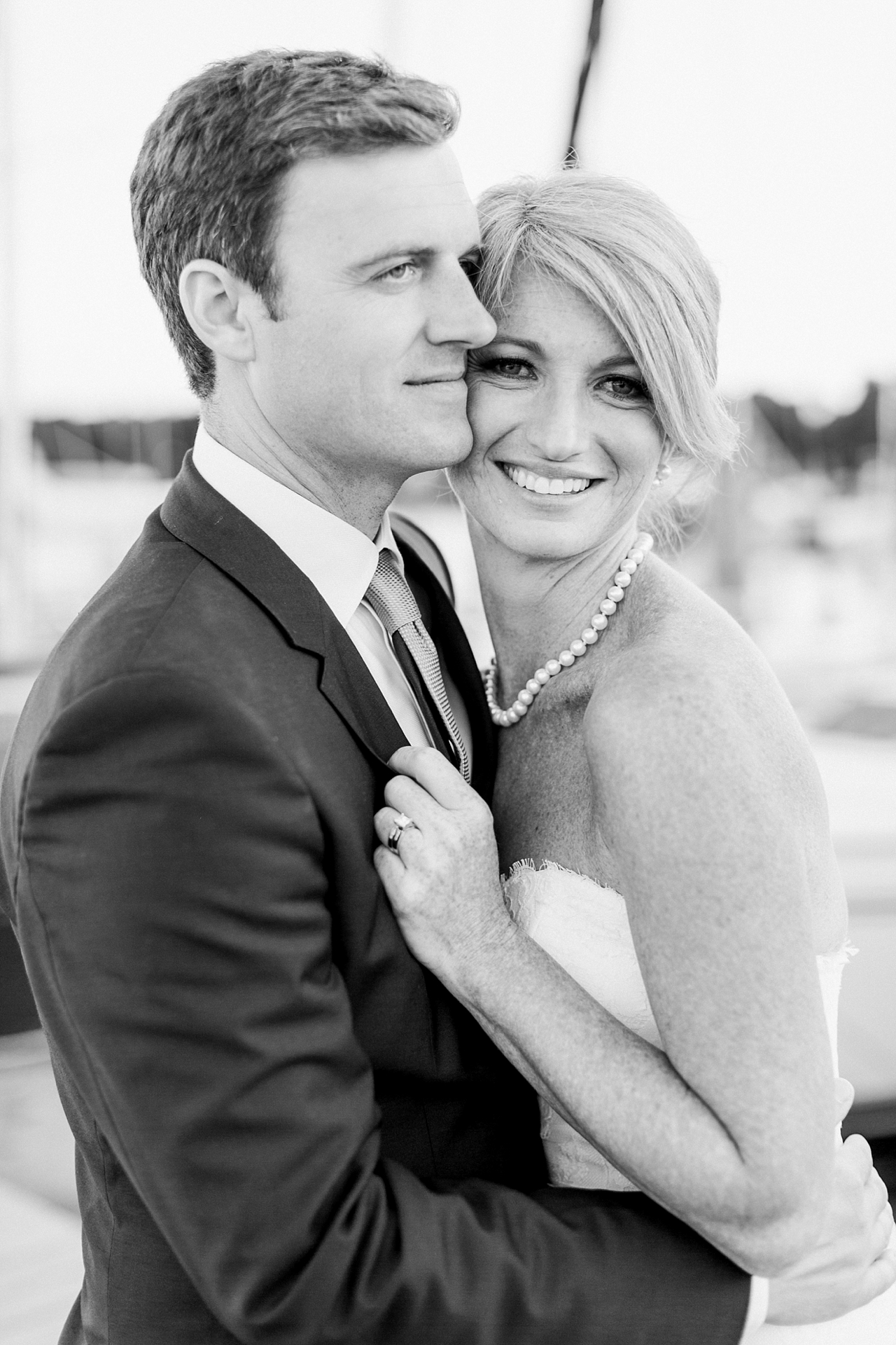 Black and white up close portrait of a smiling bride with her groom