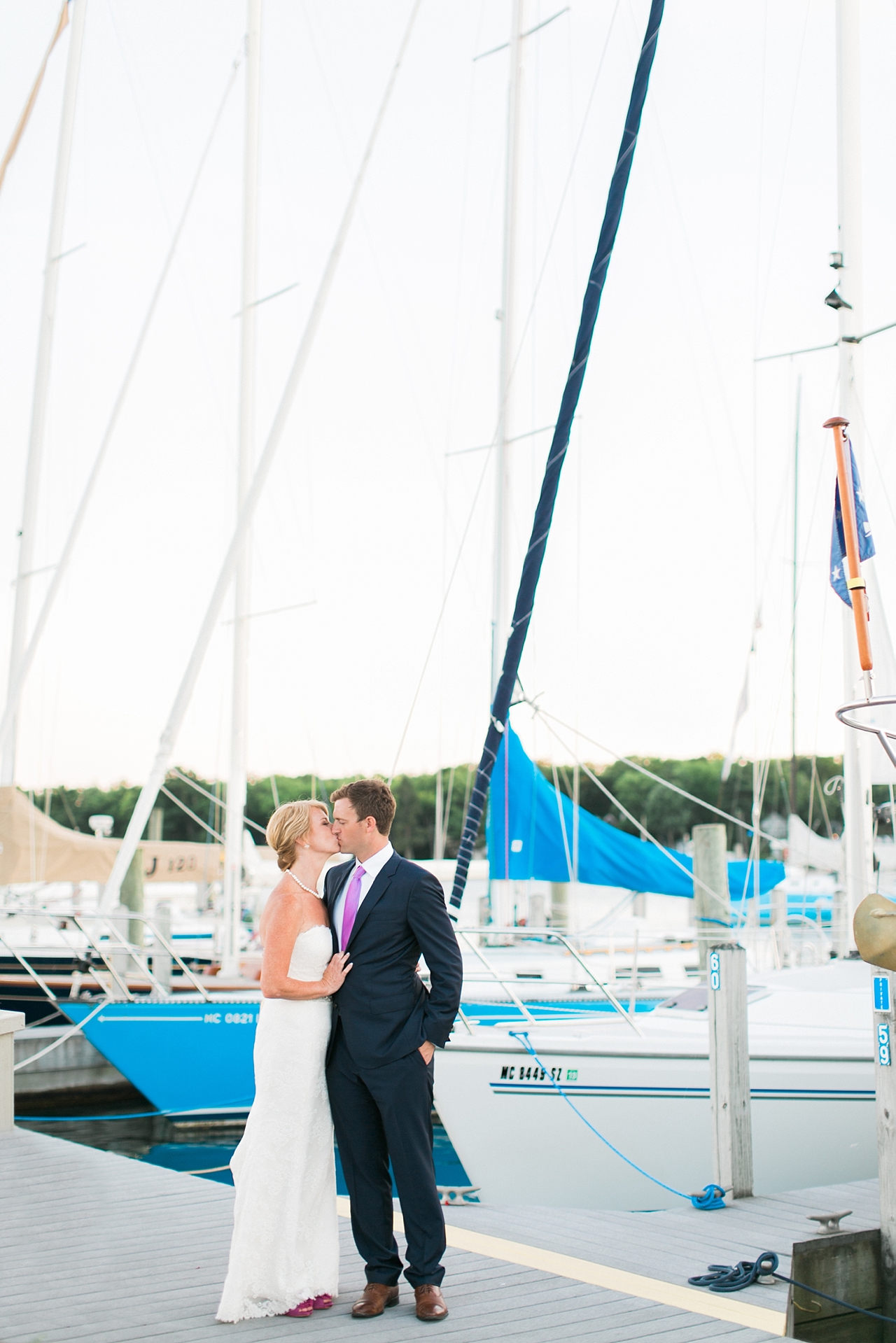 A bride and groom kissing on a dock in Harbor Springs, Michigan