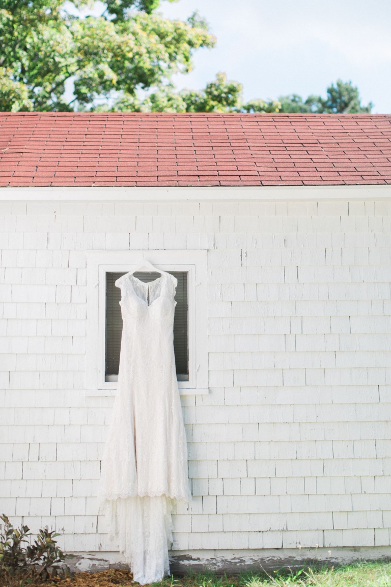 This is a photo of a wedding dress hanging on the side of a building with white siding at Fountain Point Resort