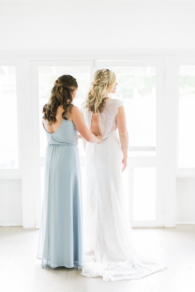 This is a bride putting on her wedding dress with the help of her sister in a cabin at Fountain Point Resort