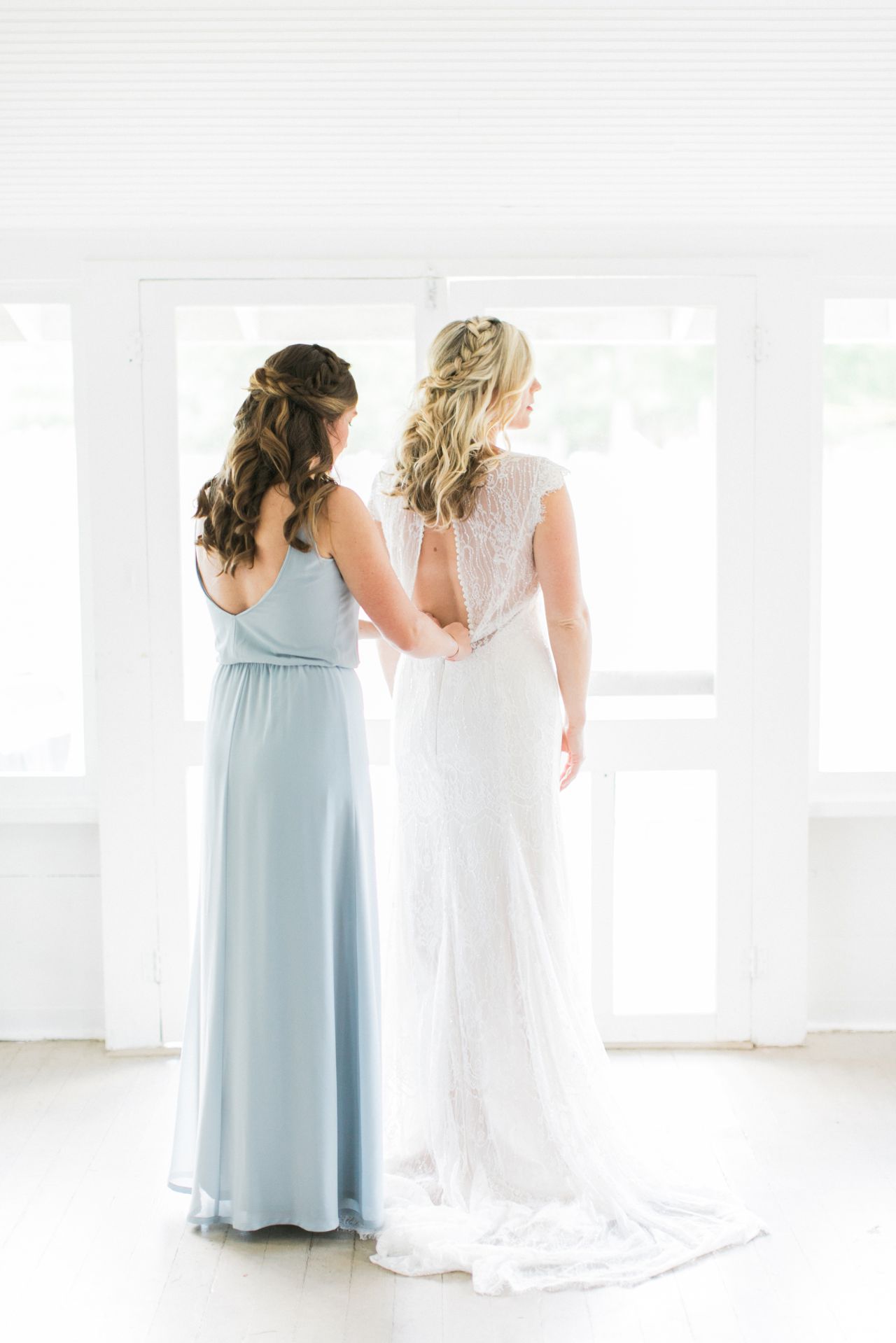 This is a bride putting on her wedding dress with the help of her sister in a cabin at Fountain Point Resort