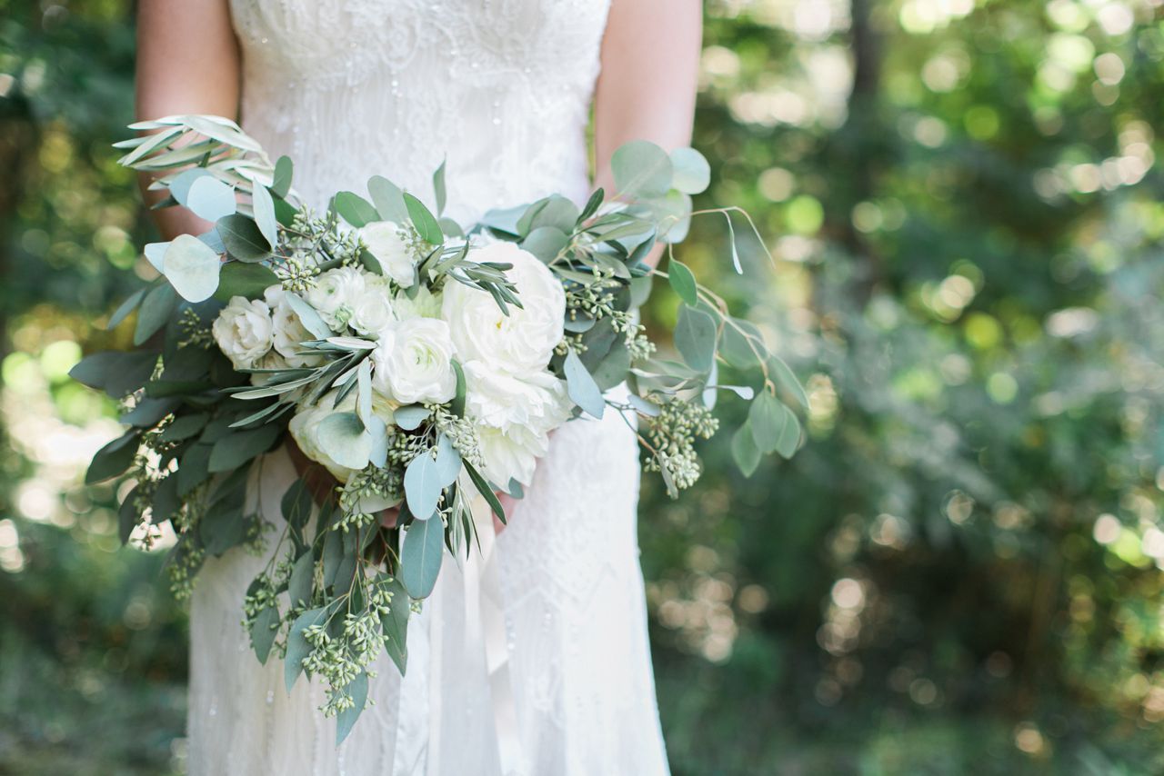 This is a photo of a bridal bouquet created by BLOOM Floral Design with white flowers and greens