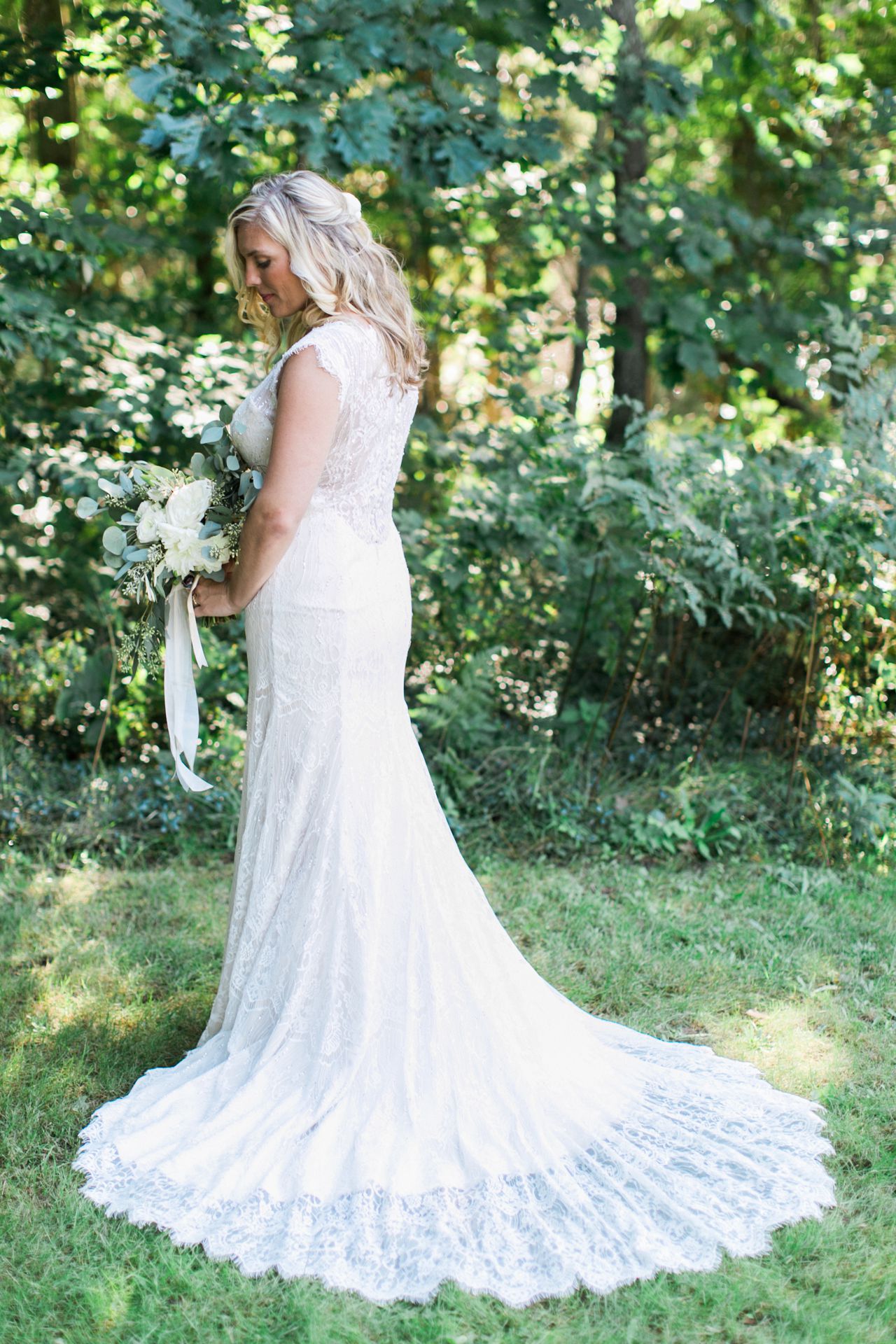 This is the back of a brides dress with the woods in the background at Fountain Point Resort 