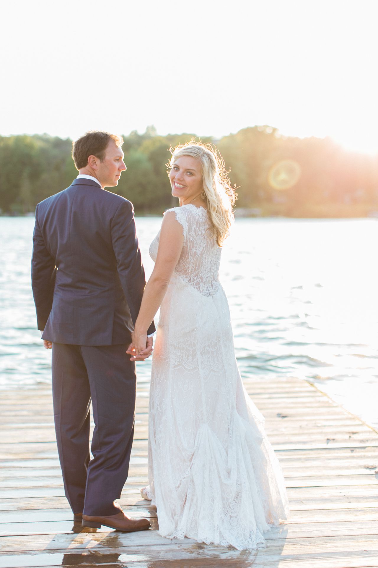 This is a photo of a bride and groom walking while holding hands and on a dock at Fountain Point Resort
