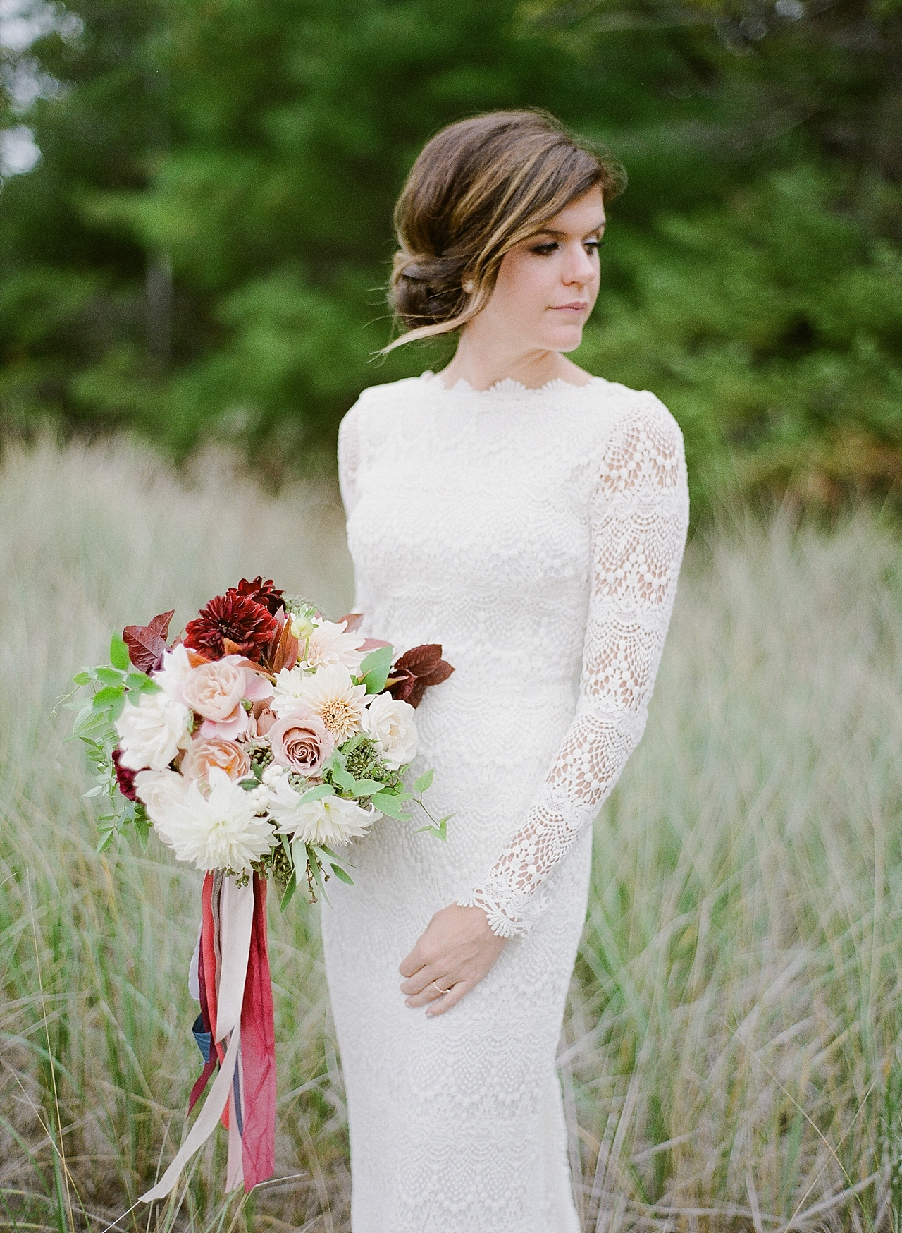 A portrait if a bride looking to the right with her bouquet in her right hand