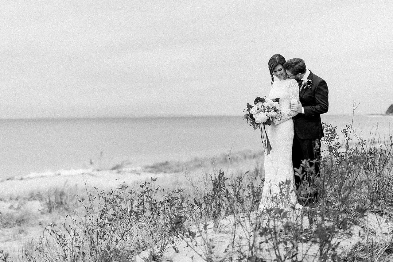 A bride and groom in the fall in sand dunes along Lake Michigan