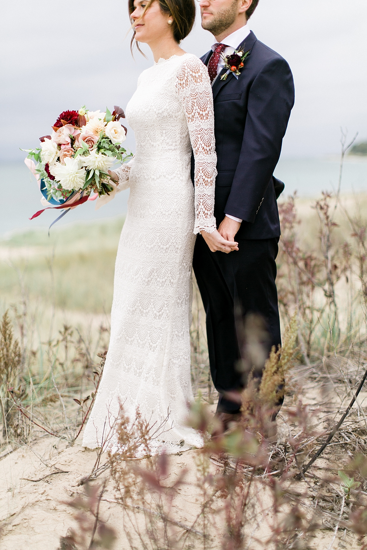 A bride and groom holding hands on a moody day in Leelanau County