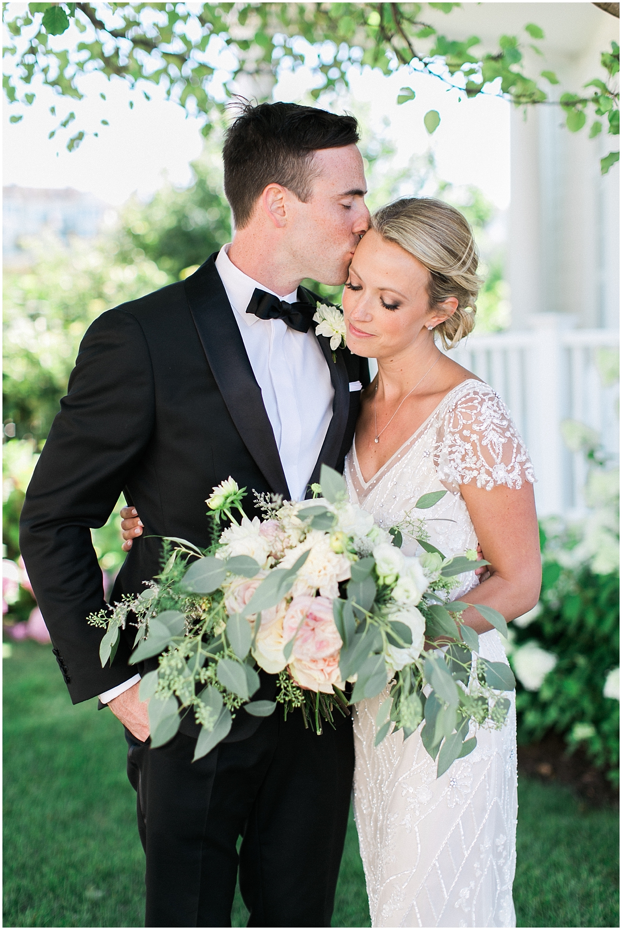 Groom kissing the brides temple in Bay Harbor, Michigan