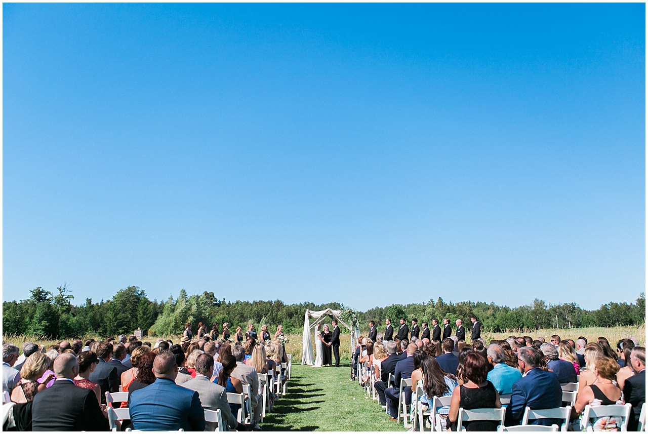 Photo of a wedding ceremony in the field at Shanahan's Barn in Charlevoix, Michigan