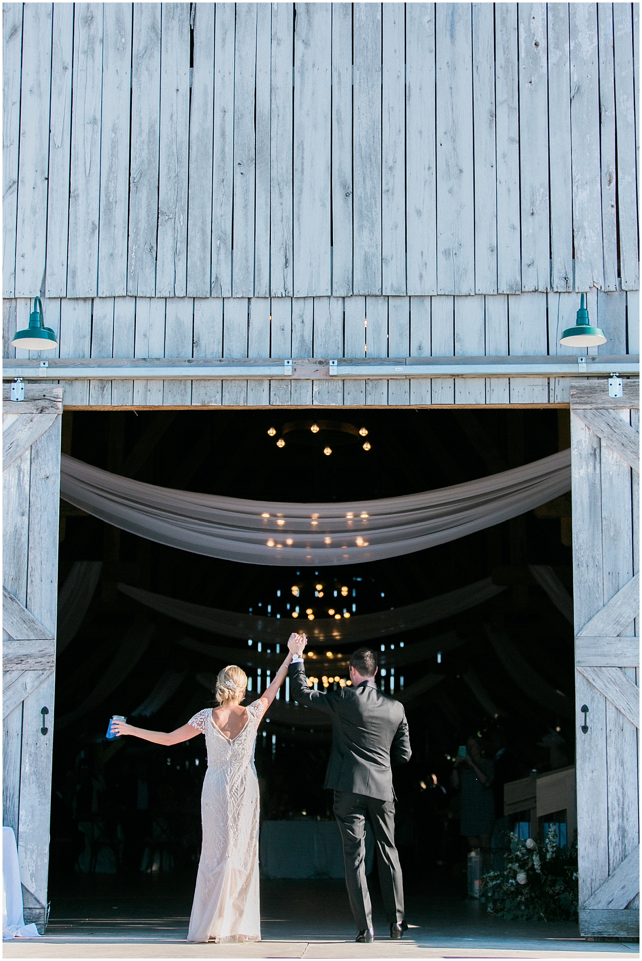 The bride and groom walking into Shanahan's barn in Charlevoix, Michigan for the reception
