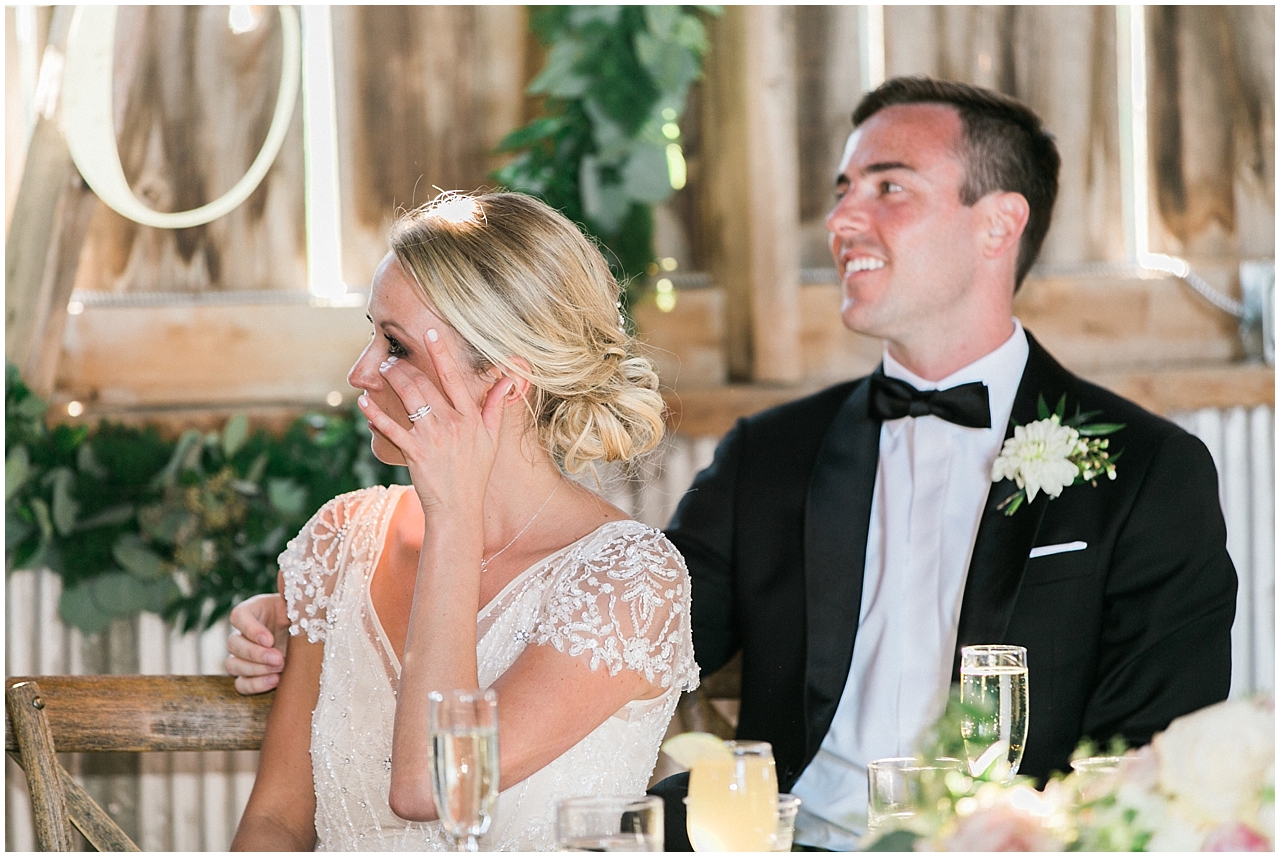 The bride spreading a tear during the speeches at the wedding reception at Shanahan's barn in Charlevoix, Michigan