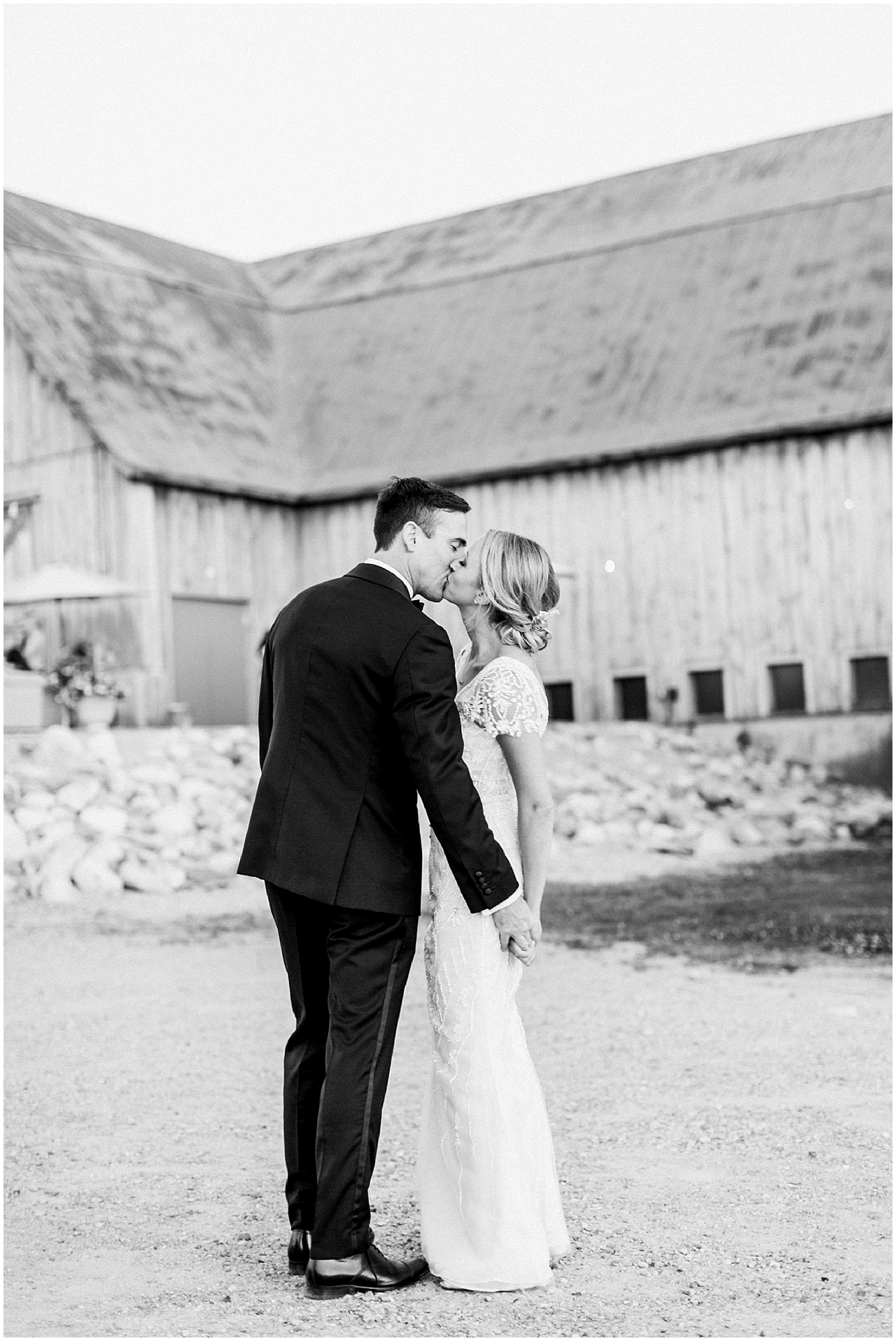 Bride and groom kissing outside of Shanahan's barn in Charlevoix, Michigan