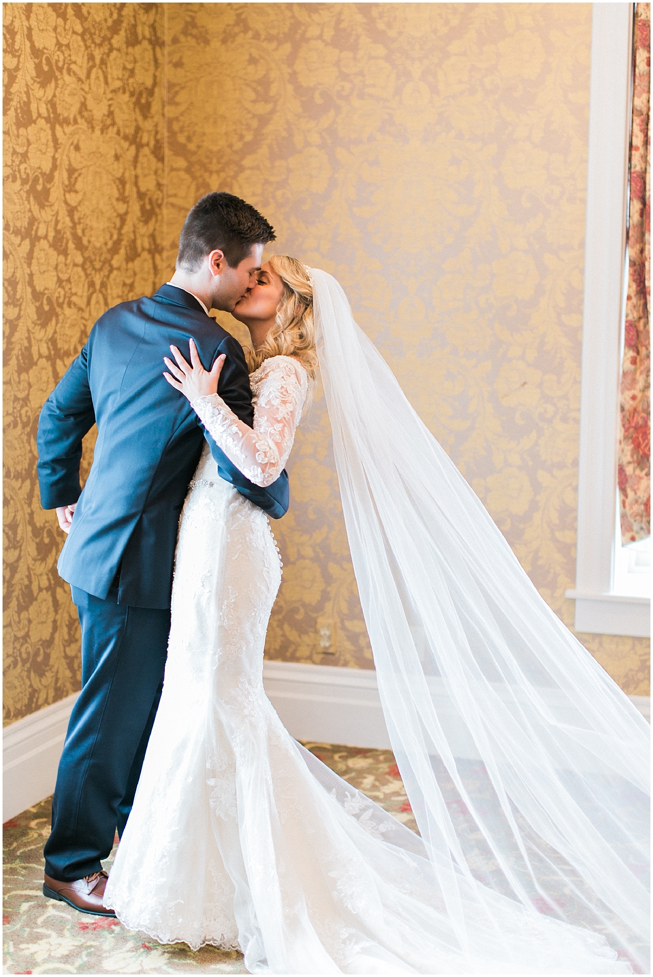 A bride and groom kissing during their first look at the Stafford's Perry Hotel