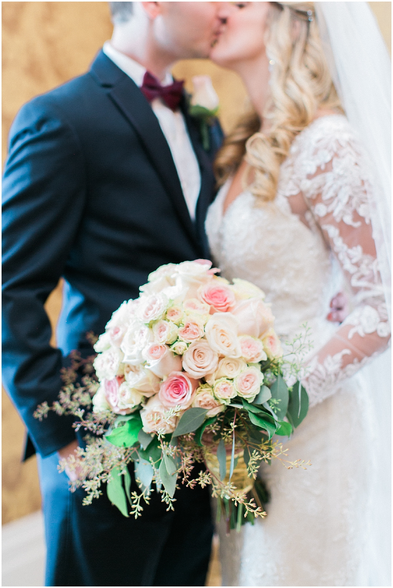 A bride and groom kissing during their first look at the Stafford's Perry Hotel