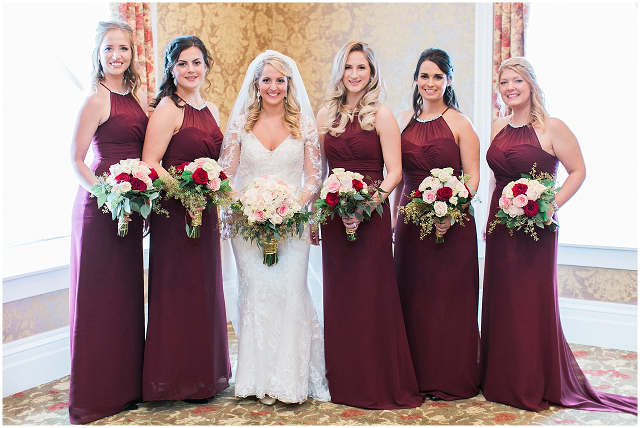 A bride and her bridesmaids who are wearing Burgundy dresses at Stafford's Perry Hotel in Petoskey, Michigan