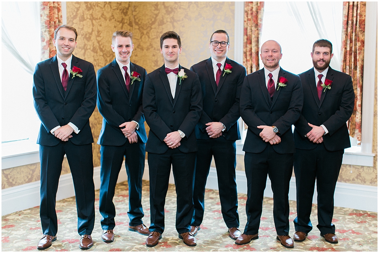 A groom and his groomsmen who are wearing Burgundy ties and black suits at Stafford's Perry Hotel in Petoskey, Michigan