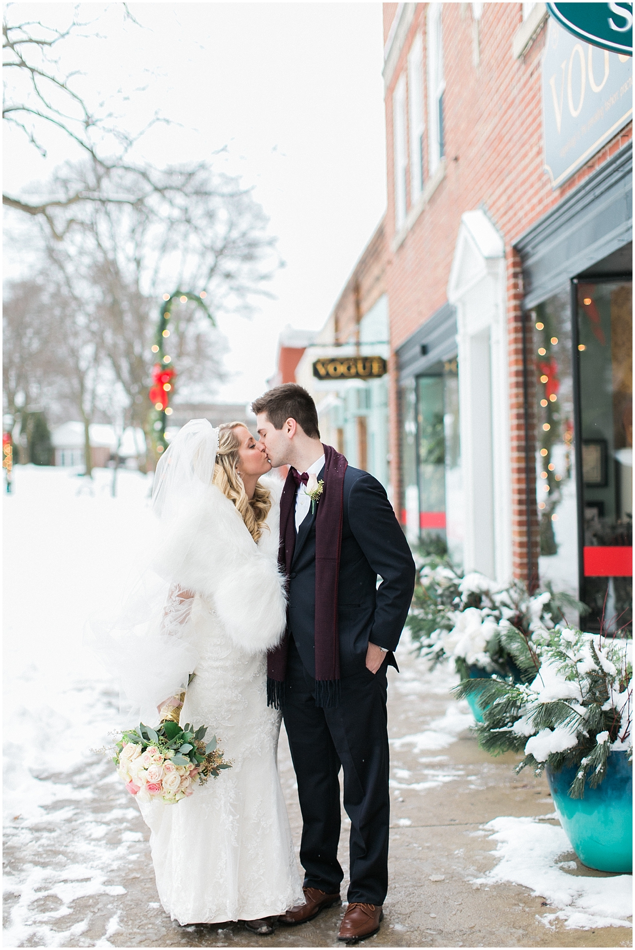 A bride and groom kissing in the winter in Downtown Petoskey