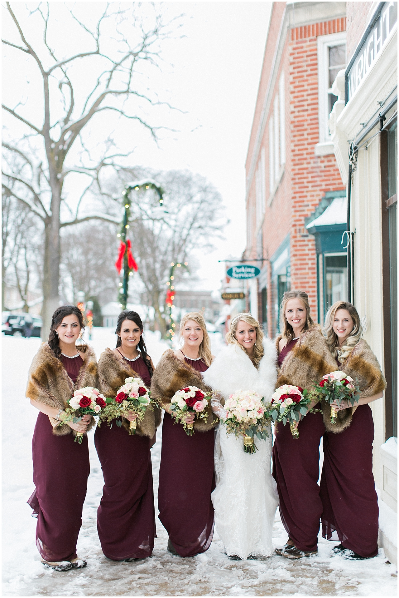 A bride and her bridesmaids who are wearing burgundy dresses in Petoskey, Michigan