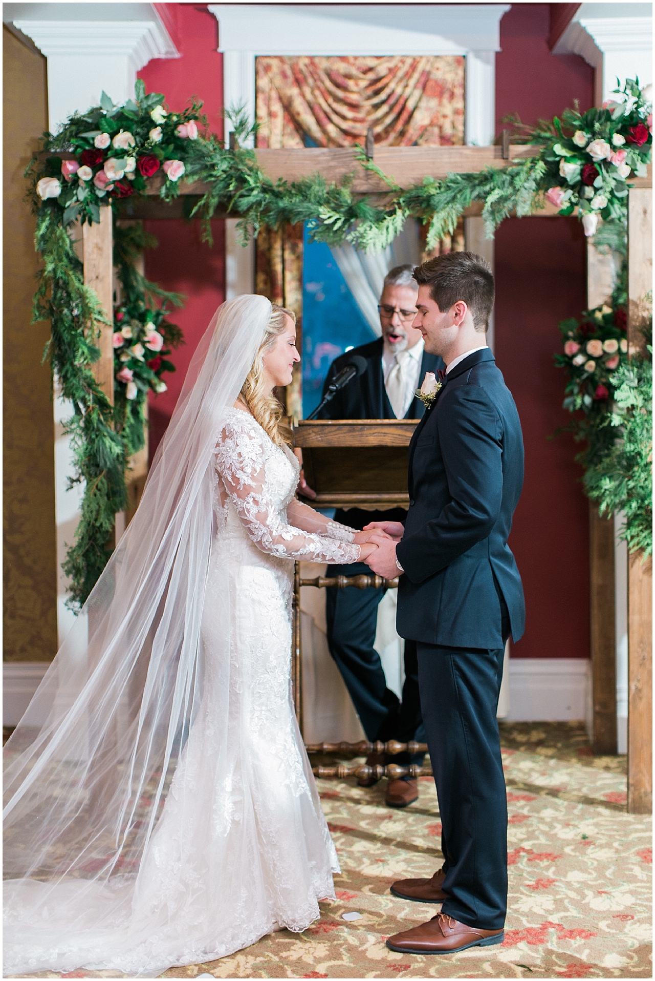 A bride and groom holding hands and exchanging their vows at the Stafford's Perry Hotel