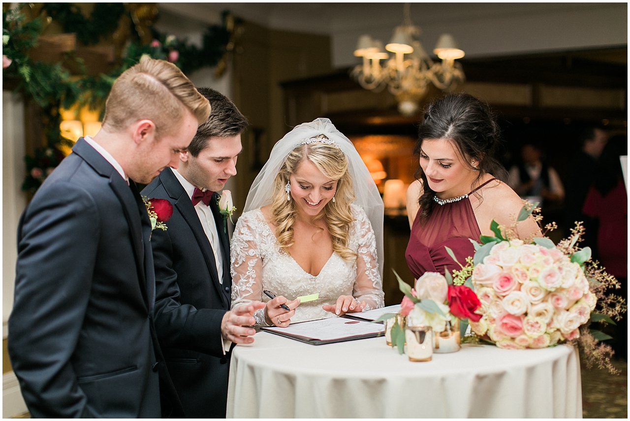 A bride and groom signing their marriage license at the Stafford's Perry Hotel
