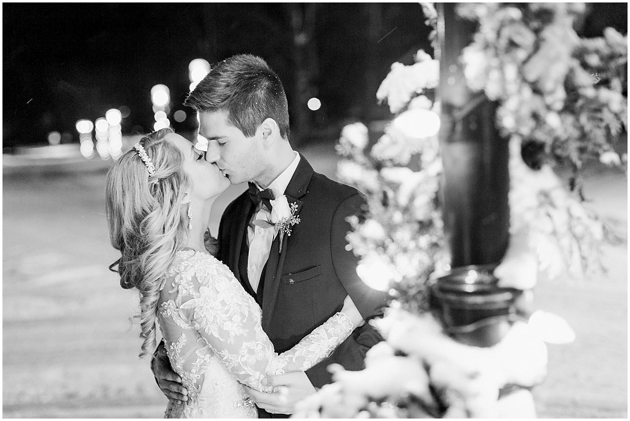 A bride and groom kissing outside the Stafford's Perry Hotel in the winter