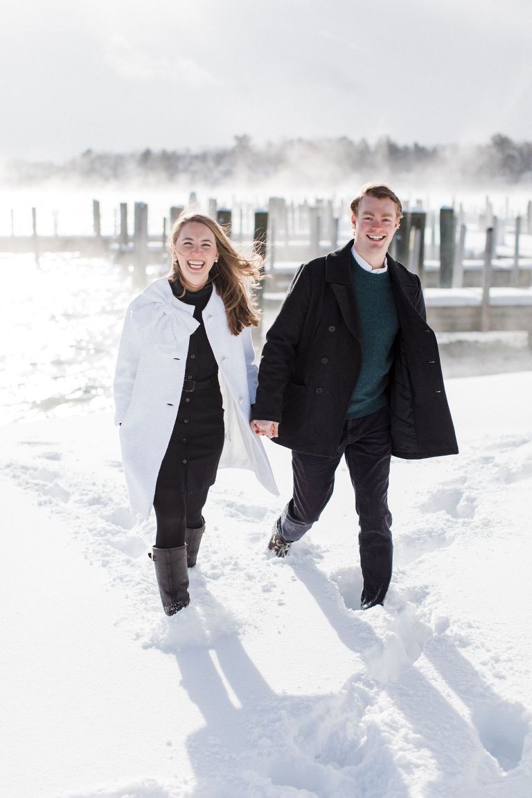 This is an engaged couple walking along the lake in Harbor Springs, Michigan