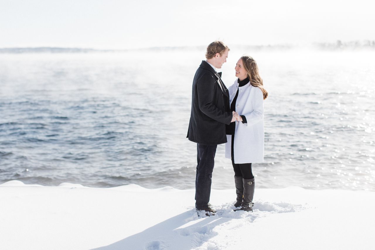 This is a couple smiling at each other while taking photos on Little Traverse Bay in Harbor Springs, Michigan