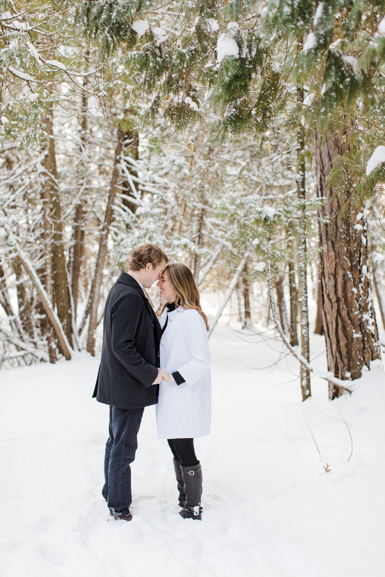 This is an engaged couple taking engagement photos in the woods in Northern Michigan