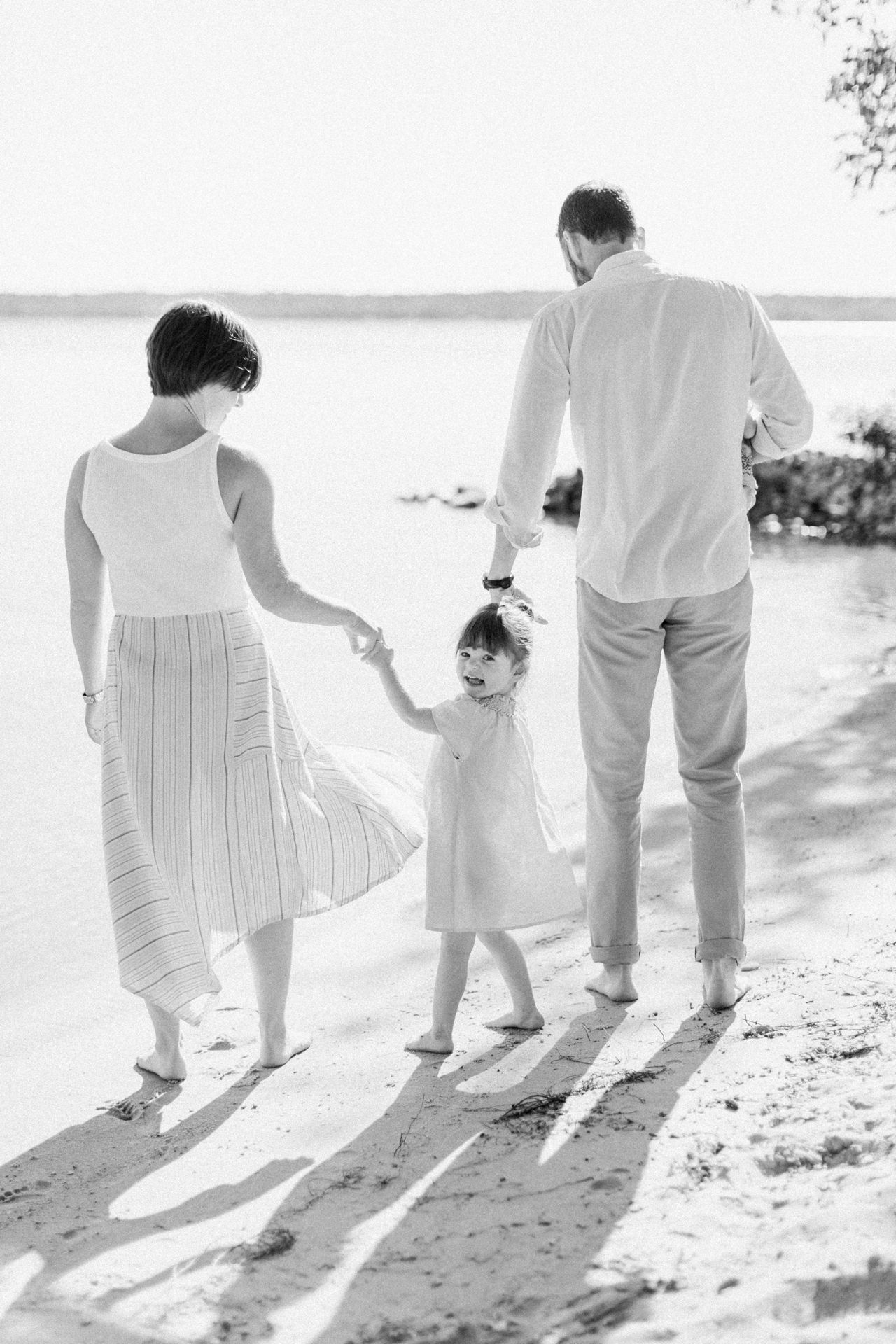 A mother and father holding their daughters hand looking at Crystal Lake