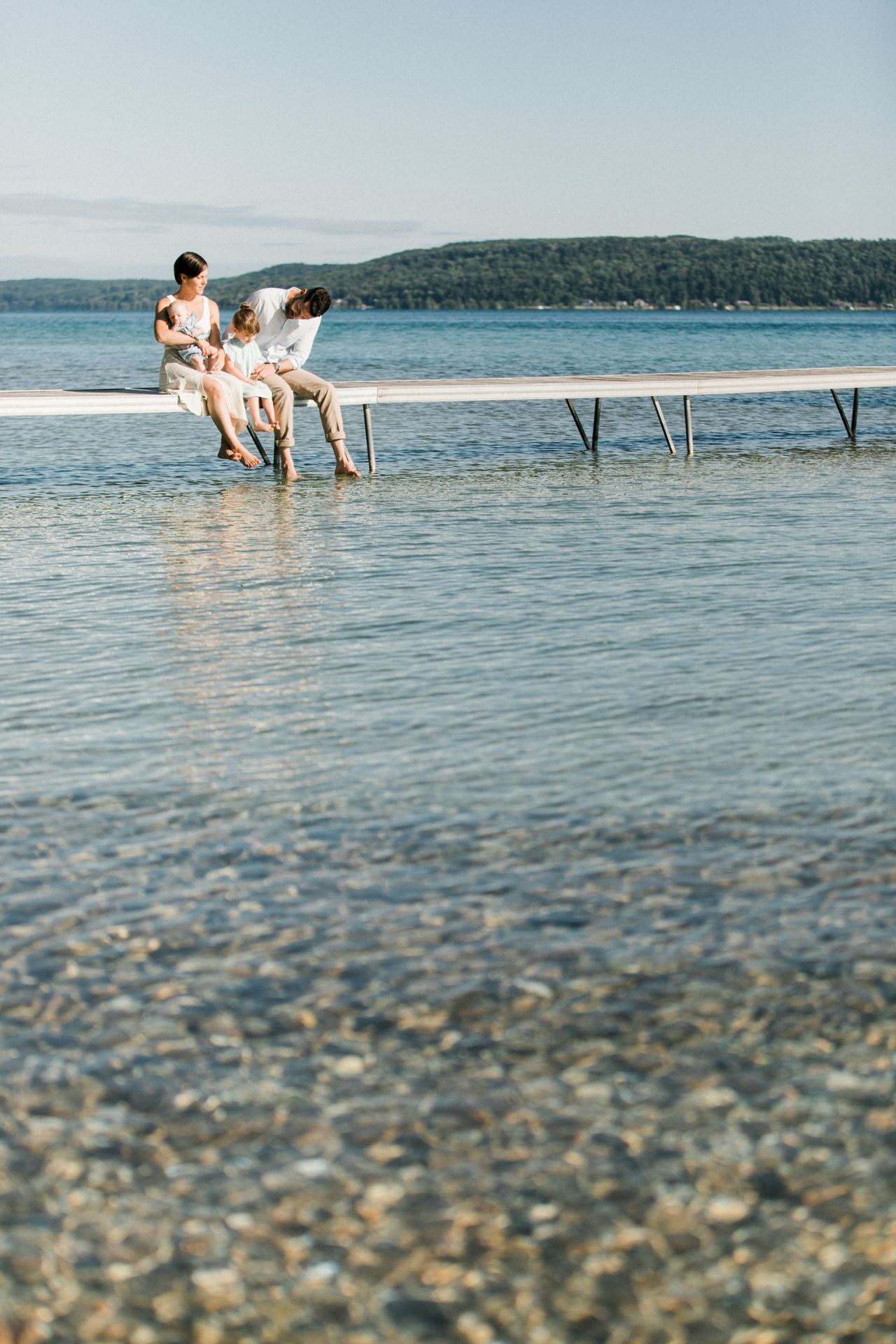 A family dipping their toes in the water on Crystal Lake