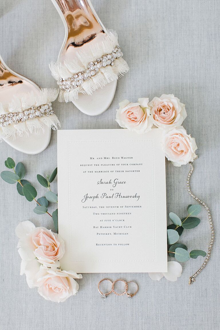 Bridal details including jewelry, invitations, and shoes