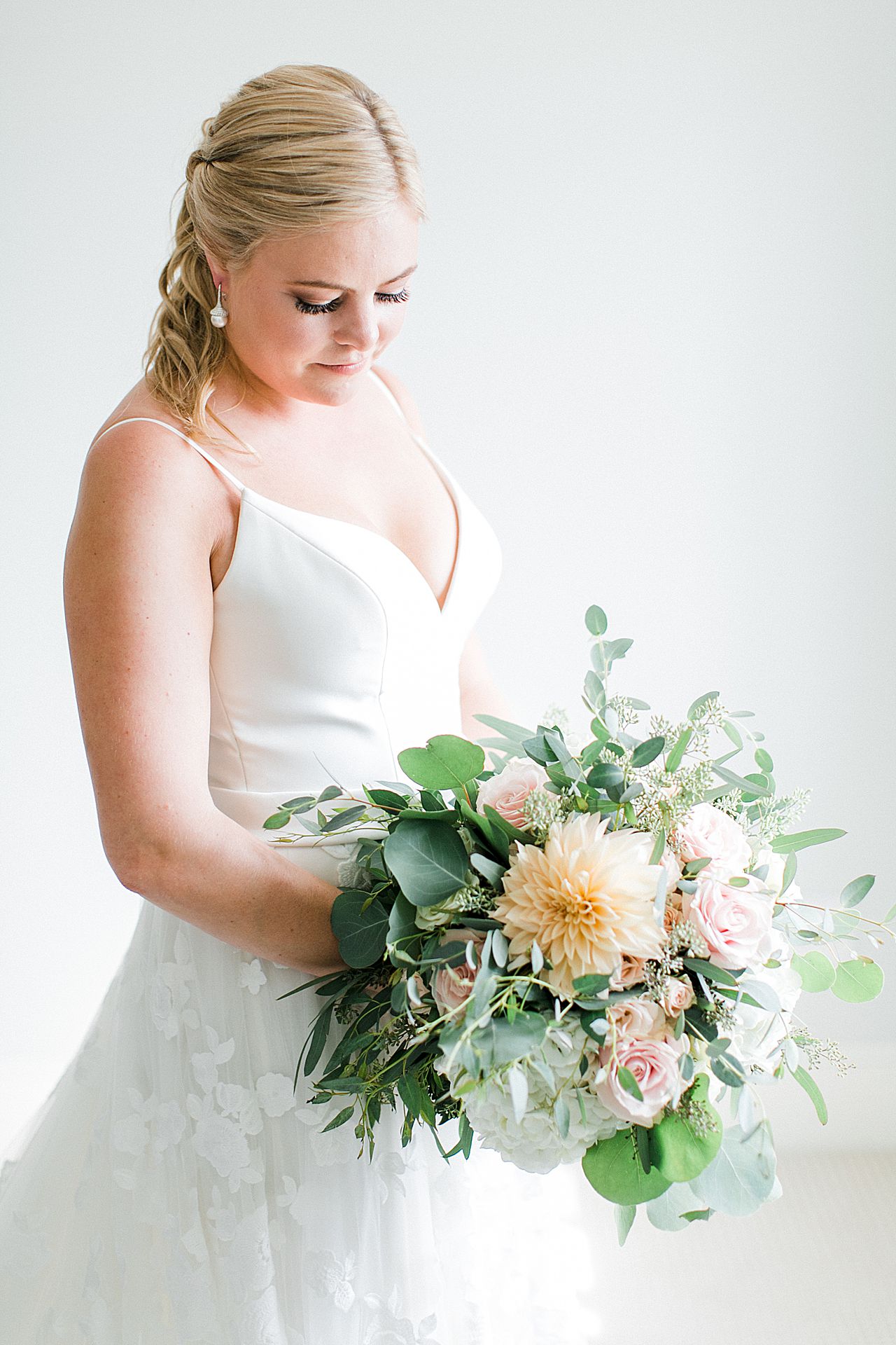 Bride looking down at her flowers at her home in Bay Harbor Michigan
