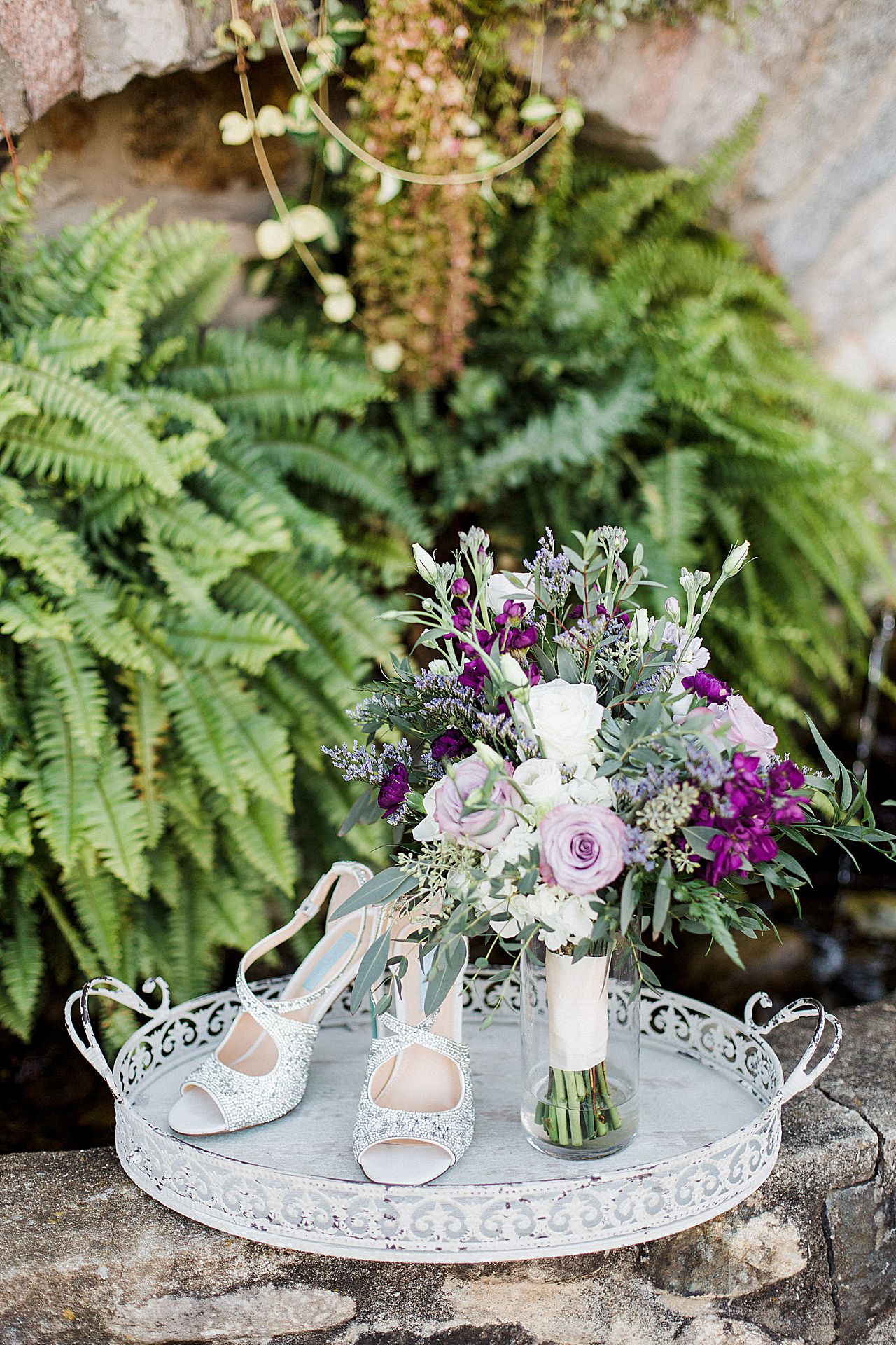This is a photo of sparkly shoes, and a bouquet with purple and white flowers