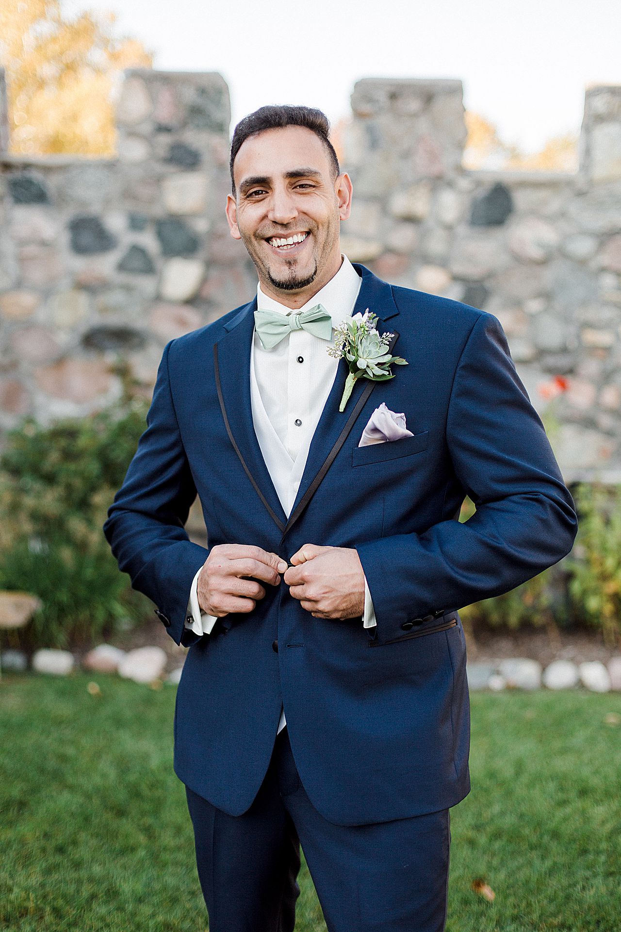 This is a photo of a groom smiling in Charlevoix, Michigan
