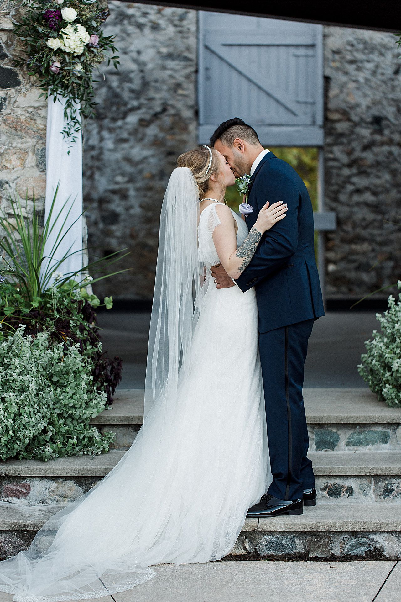 This is a photo of a bride and groom's first kiss at their ceremony in the Knight's Courtyard at Castle Farms in Charlevoix, Michigan