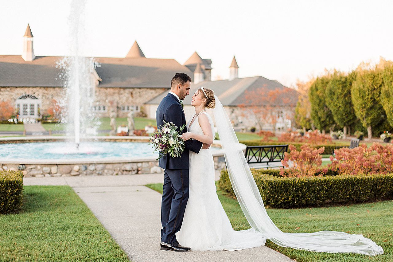Bride and groom portraits in the Kings Grand Courtyard at Castle Farms with a fountain in the background