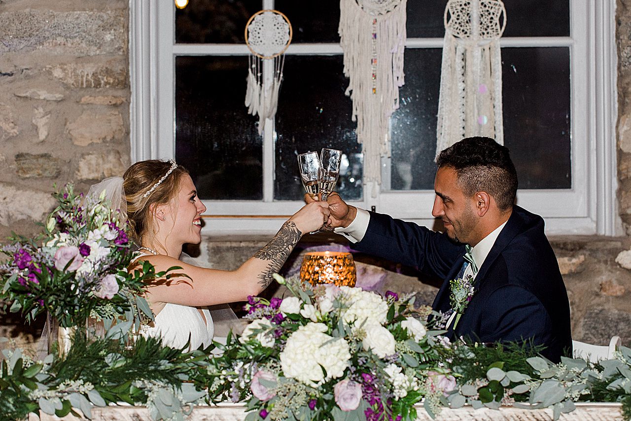 A bride and groom sharing a cheers and clinking their glasses at the wedding reception.