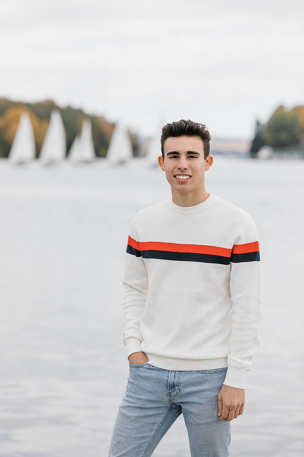 High school senior posing in front of sail boats in Charlevoix, Michigan