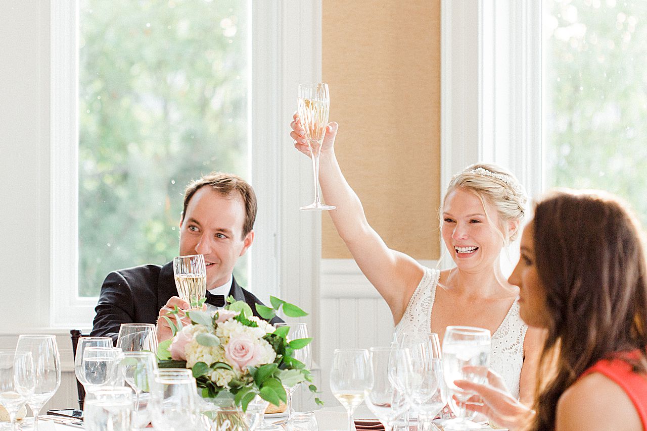 A bride raising her glass after a toast at a wedding reception