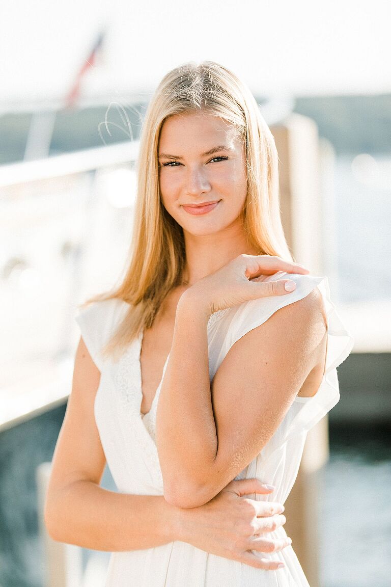 This is a photo of a high school senior girl on a dock at a marina in Boyne City, Michigan