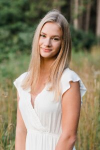 This is a senior portrait session of a girl at sunset in a field during golden hour