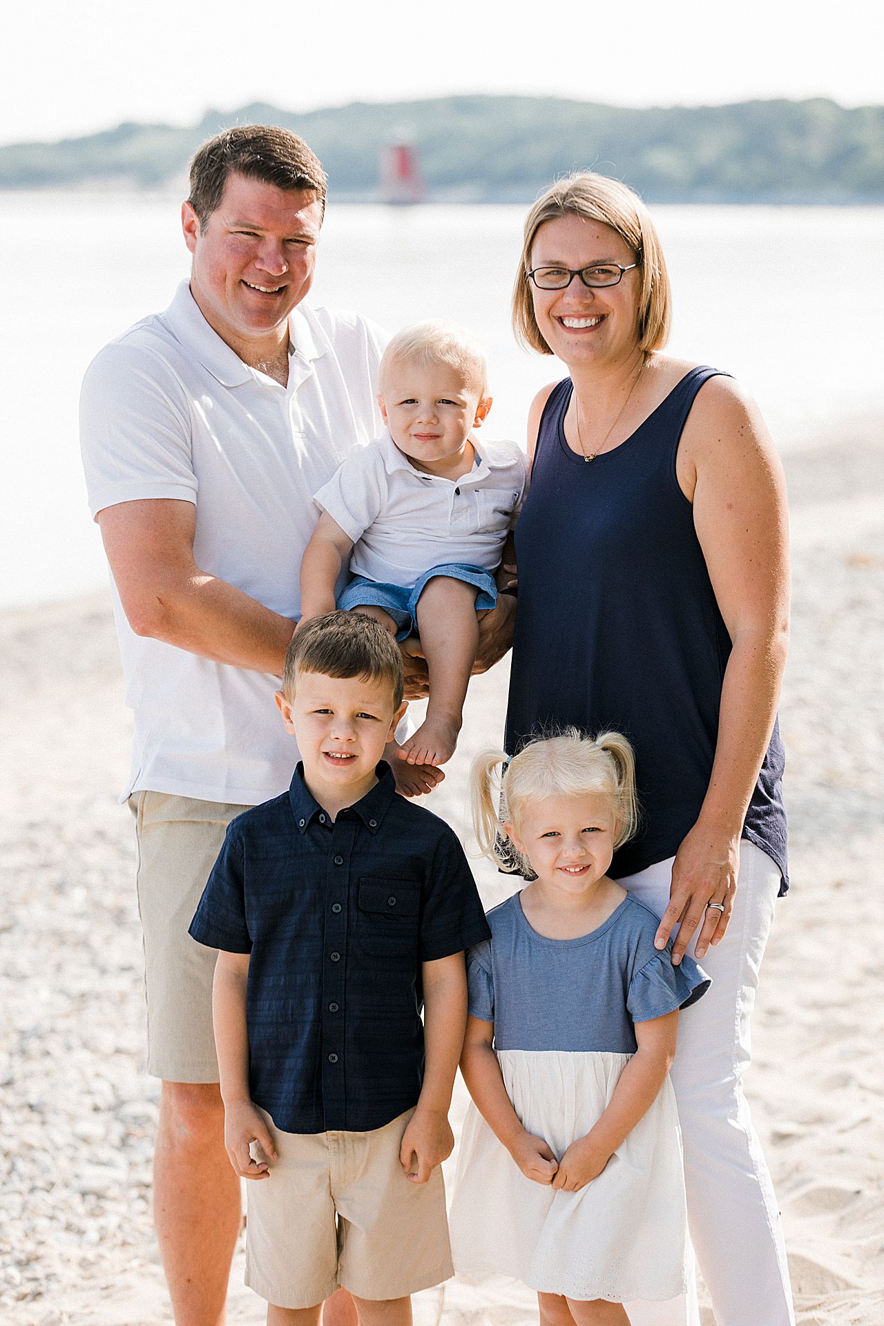 Mother and father with their two sons and their daughter on a beach in Michigan