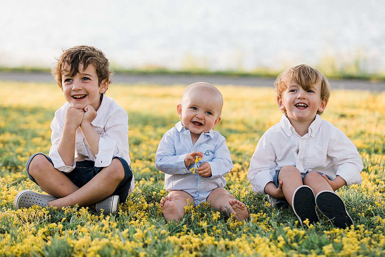 Three young brothers sitting in the grass together